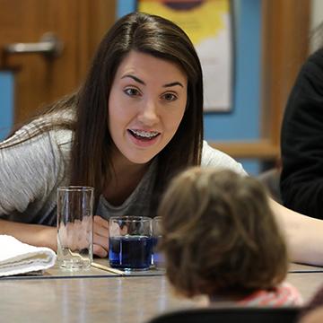 A student talks with a young child.